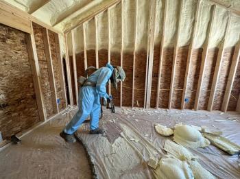 A spray foam technician spraying foam in a  home