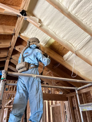 A technician installing spray foam in 